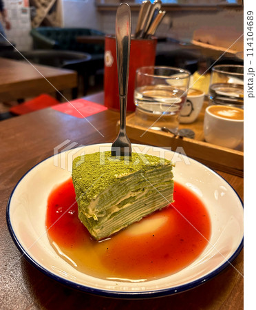 a piece of matcha cake with cranberry sauce 114104689