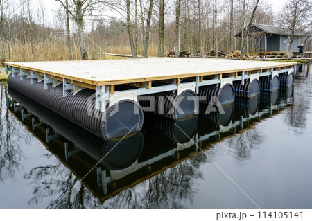 A new empty wooden platform on pontoons in the lake for the creation of a holiday house on the water A new empty wooden platform on pontoons in the lake for the creation of a holiday house on the water 114105141