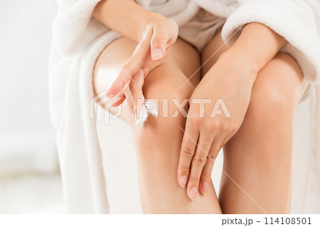 女性は膝にクリームを塗っている. 女性は膝にクリームを塗っている. 114108501