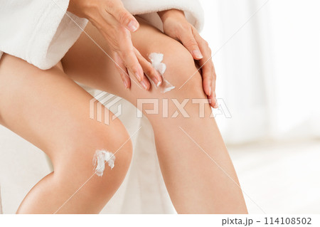 女性は膝にクリームを塗っている. 女性は膝にクリームを塗っている. 114108502