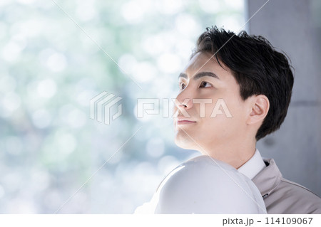 ヘルメットを持ってハンサムな若い作業員のクローズアップ 未来や希望を見つめる新卒採用など 114109067