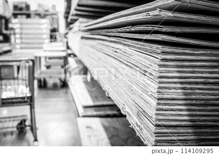 Selective focus on corner edge of stacked plywood at a lumberyard hardware store. 114109295