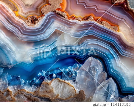 A close-up of a colorful, layered mineral geode with sharp crystal formations. 114113196