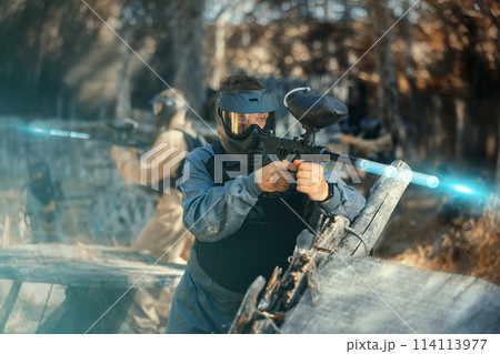 Man aiming with paintball market on battleground 114113977