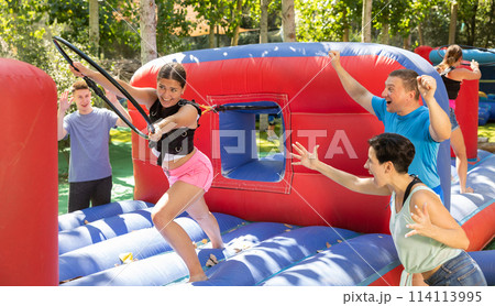 Playful girl competing to collect hoops on inflatable playground 114113995