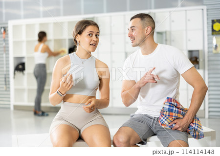 Man and two women talking in locker room 114114148