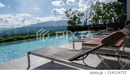 Picture of a sun bed chair on the edge of a hotel or resort rooftop swimming pool Picture of a sun bed chair on the edge of a hotel or resort rooftop swimming pool 114114737