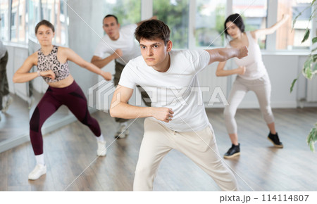 Young Hispanic guy enjoying energetic dance at group class 114114807