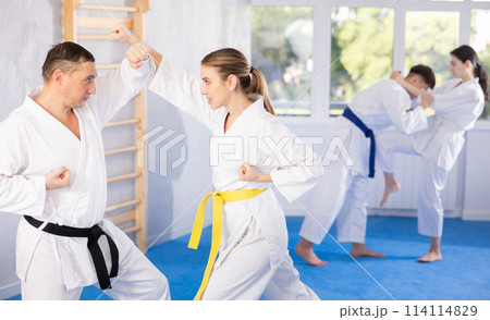 Adult man and young woman training karate techniques 114114829