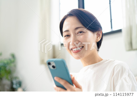 スマホを持って笑顔の女性 114115977