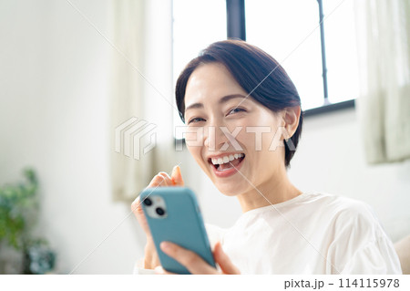 スマホを持って笑顔の女性 スマホを持って笑顔の女性 114115978