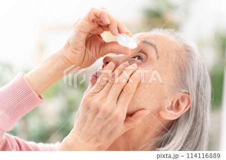 目薬をさすシニア女性 114116889