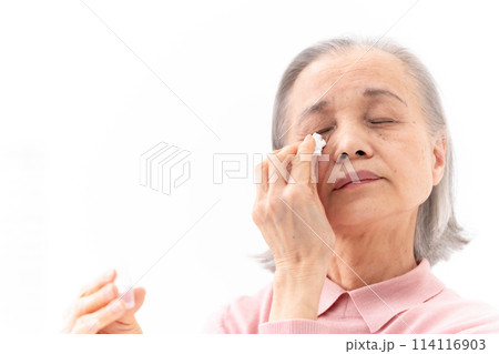 目薬をさすシニア女性 114116903