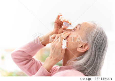 目薬をさすシニア女性 114116904