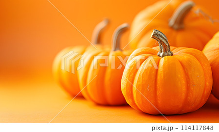 Row of pumpkins on orange backdrop, staple and natural foods 114117848
