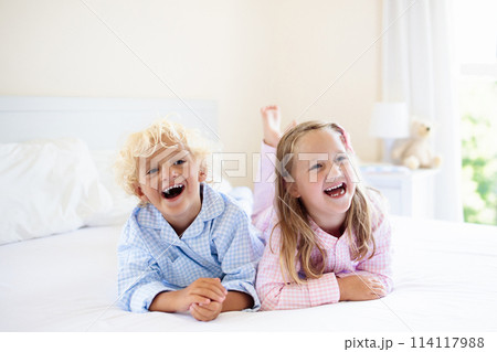 Kids in bed. Children in pajamas. Family bedroom. 114117988