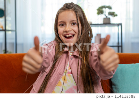 Child girl kid looking approvingly at camera showing double thumbs up like sign positive feedback 114118588