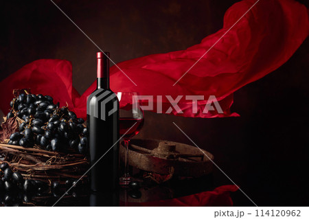 Red wine with grapes on a background of red flutters curtain. 114120962