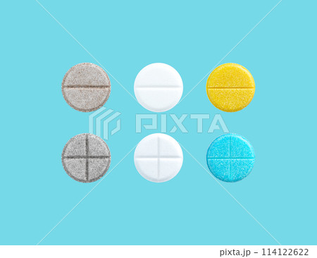 Different colored pills in a row on blue background with copy space. Biologically active additives. Medical concept. 114122622