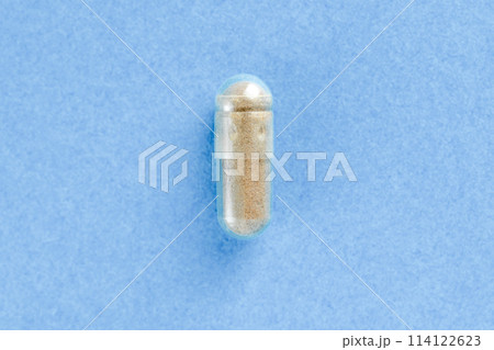 Brown two-piece hard starch capsule on blue background with copy space. Medical and Health concept. 114122623