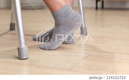 Elderly woman wear non slip grip socks for senior people who have trouble keeping their balance. Elderly woman wear non slip grip socks for senior people who have trouble keeping their balance. 114122722