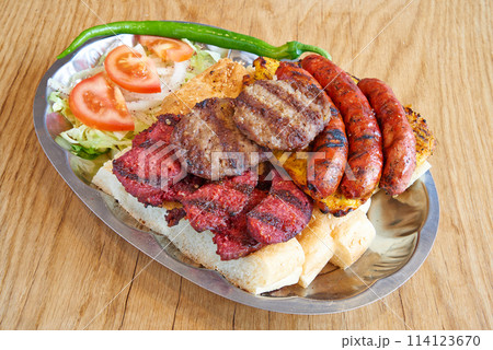 Mixte meal and  sandwich on metal plate on wooden textured table 114123670