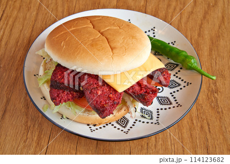 Beef burger on decorated plate on wooden textured table 114123682