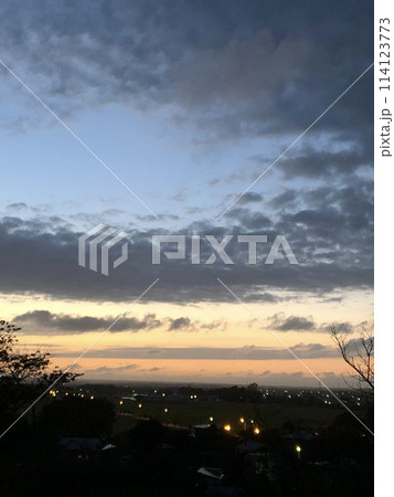 雲の隙間から見える夕日 114123773