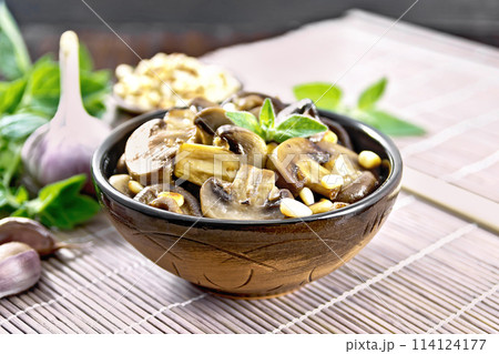 Champignons with oregano and nuts in bowl on dark board 114124177