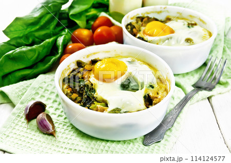 Scrambled eggs with spinach in bowl on board Scrambled eggs with spinach in bowl on board 114124577