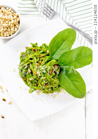 Spaghetti with spinach and nuts in plate on board top 114124638