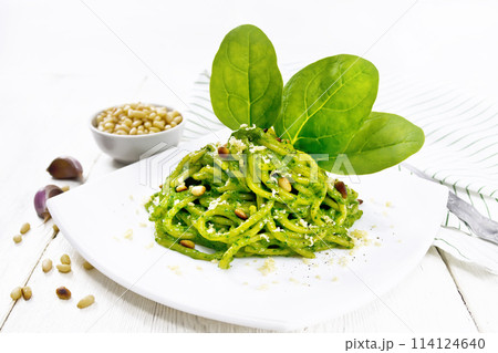 Spaghetti with spinach and nuts in plate on light board 114124640