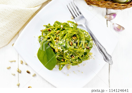Spaghetti with spinach and pine nuts in plate on board top 114124641