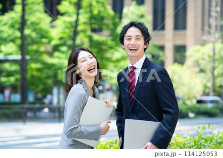 オフィス街でパソコンを持つビジネスパーソン 114125053