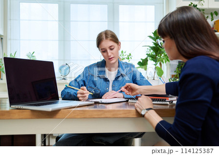 Young teenage girl talking with psychologist, therapist Young teenage girl talking with psychologist, therapist 114125387