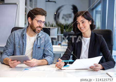 Colleagues working in collaborative office environment Colleagues working in collaborative office environment 114125757