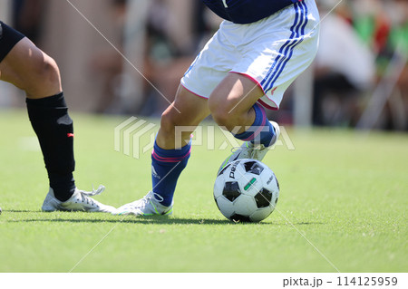 サッカーの試合でドリブルをする選手 サッカーの試合でドリブルをする選手 114125959