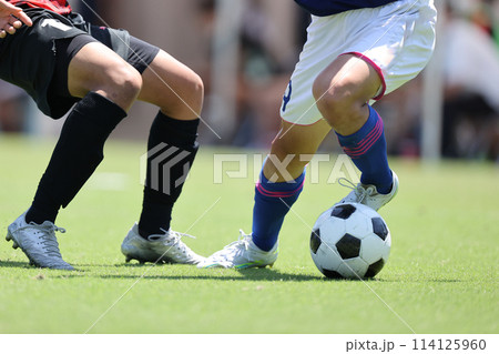 サッカーの試合でドリブルをする選手 サッカーの試合でドリブルをする選手 114125960