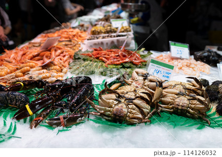 Fresh lobster, shrimps, crabs, sea urchin and other seafood on market counter. Food stalls at La Boqueria market in Barcelona 114126032