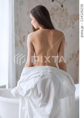 Nude brunette female back with clean and fresh skin after bathing Nude brunette female back with clean and fresh skin after bathing 114126230