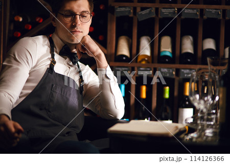 Portrait of confident male sommelier tasting red wine. Winemaking. Occupations. Portrait of confident male sommelier tasting red wine. Winemaking. Occupations. 114126366