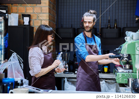 Teamwork, man and woman in aprons working together at bar counter in coffee shop cafe 114126830