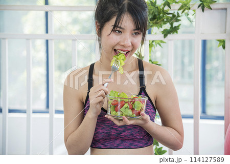 Healthy woman workout holding organic salad bowl healthy lifestyle. Wellness Asian women dressing organic green salad tomato vegetable dish. Beautiful girl healthcare vegan wellness lifestyle concept 114127589