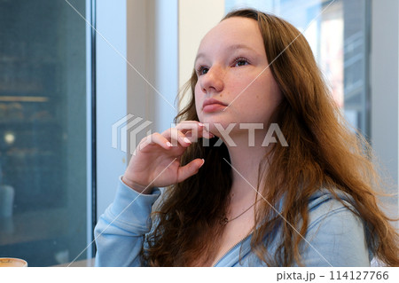 Depressed young woman near window at home, closeup Depressed young woman near window at home, closeup 114127766