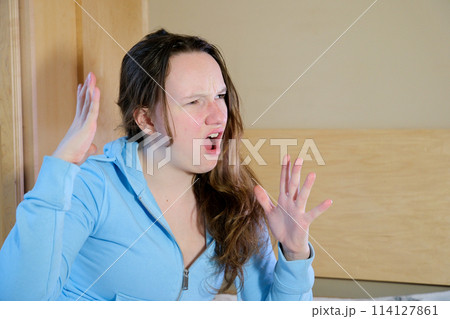 Do not miss. Young casual teen girl shouting. Shout. Crying emotional teenager screaming on blue studio background. Female half-length portrait. Human emotions, facial expression concept. Trendy Do not miss. Young casual teen girl shouting. Shout. Crying emotional teenager screaming on blue studio background. Female half-length portrait. Human emotions, facial expression concept. Trendy 114127861