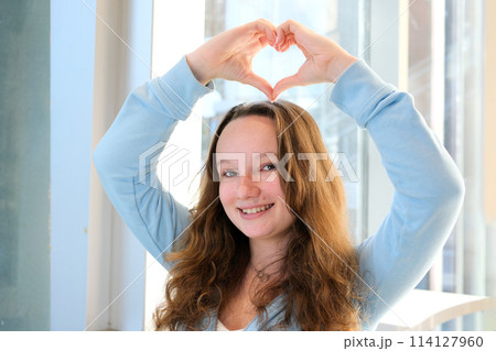 Slow motion close up portrait of an adult woman,smiling presenting with her optimistic,carefree ,vibrant attitude and sparkling white teeth.Concept of happy mood,oral hygiene,dental care. 114127960