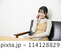 ノートパソコンを使いながら電話をする女性 114128829