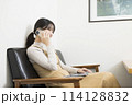 ノートパソコンを使いながら電話をする女性 114128832