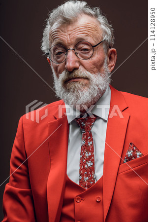 Mature musician having tired sad eyes poses in red suit on black Mature musician having tired sad eyes poses in red suit on black 114128950