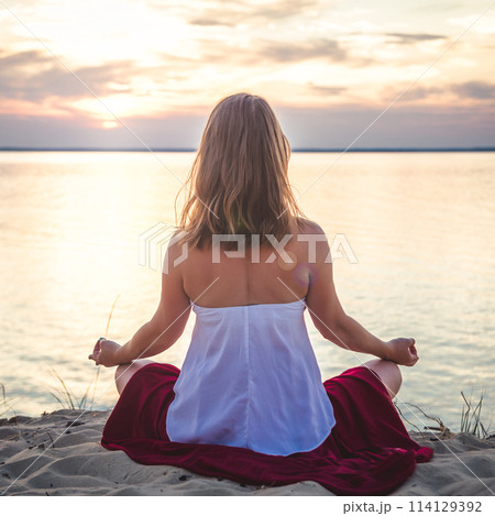 Woman meditating at the sea 114129392
